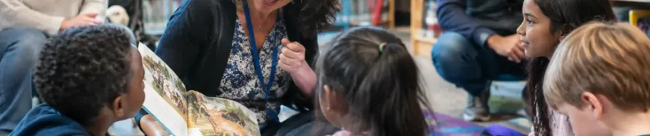 Alachua County Reads volunteers helping children with books at a community table